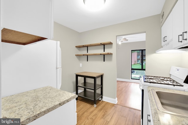 kitchen with light wood-type flooring, white cabinetry, sink, and white range with gas stovetop