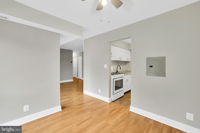 interior space featuring white range, ceiling fan, light hardwood / wood-style flooring, electric panel, and white cabinetry