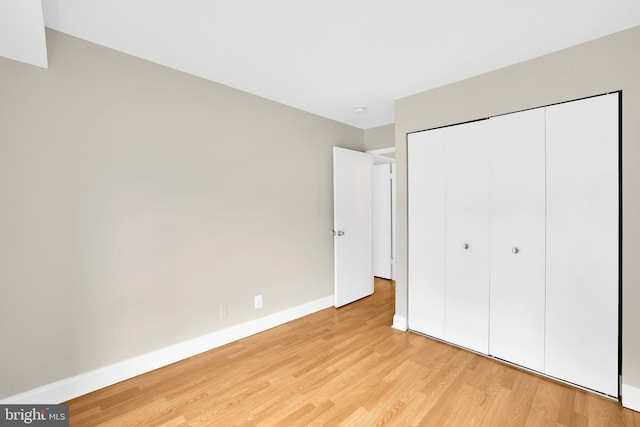 unfurnished bedroom with light hardwood / wood-style floors and a closet