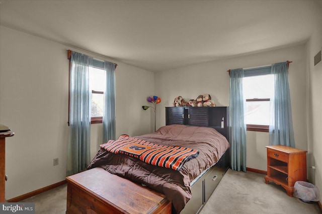 bedroom featuring multiple windows and light carpet