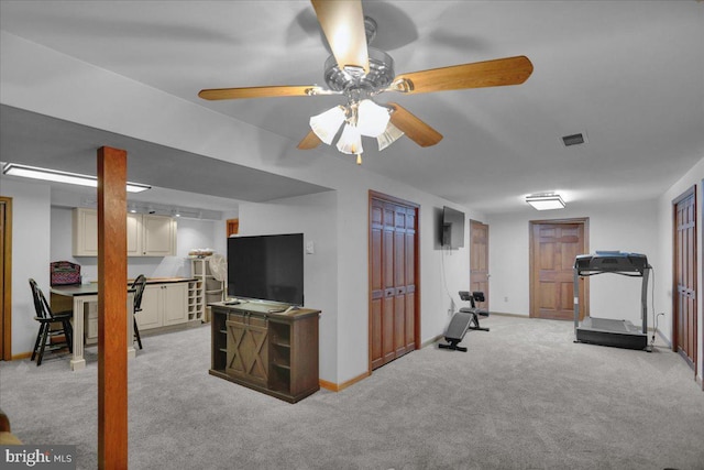 workout area with light carpet and ceiling fan