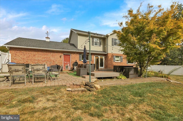 back of house featuring a lawn, central air condition unit, and a patio