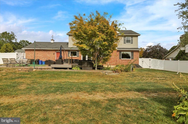 rear view of house with a yard and a deck