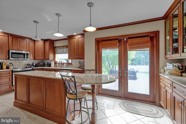 kitchen with french doors, a healthy amount of sunlight, tasteful backsplash, decorative light fixtures, and appliances with stainless steel finishes