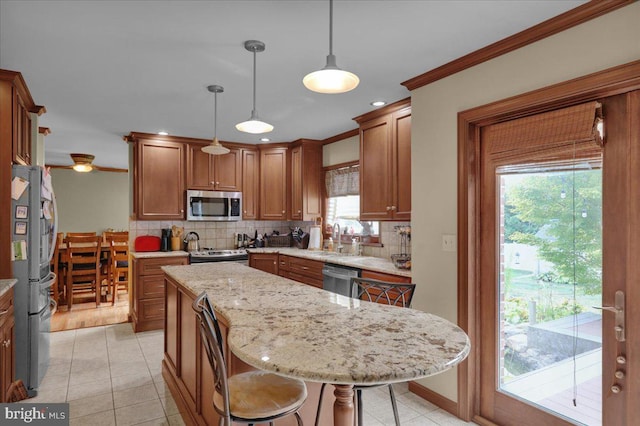 kitchen featuring a breakfast bar, stainless steel appliances, crown molding, pendant lighting, and a center island