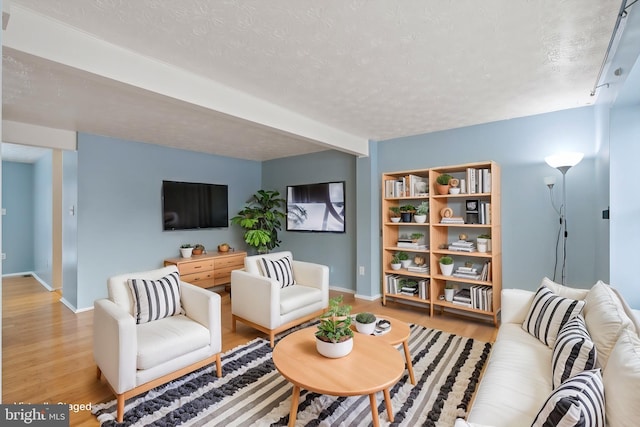 living room featuring a textured ceiling and light hardwood / wood-style flooring