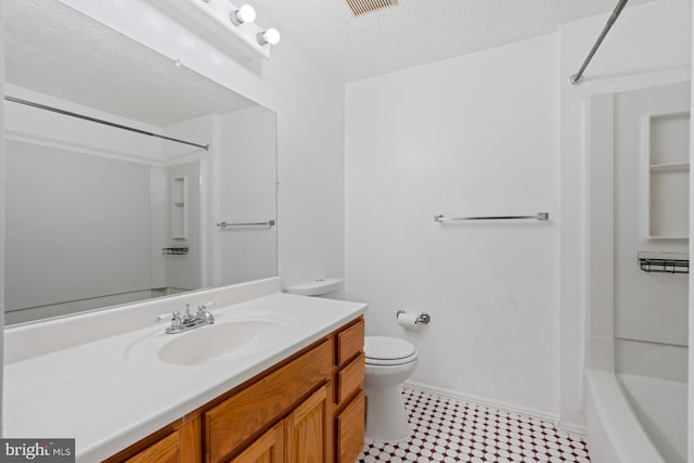 bathroom with vanity, toilet, and a textured ceiling