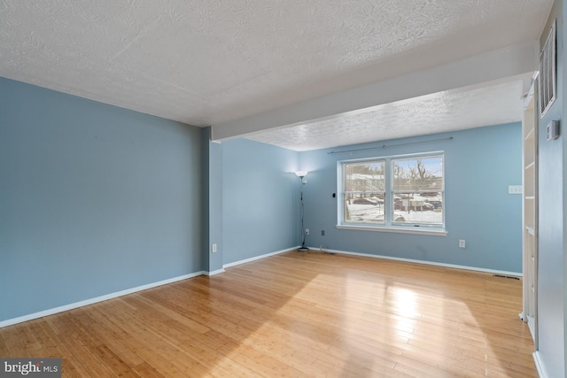 spare room with light hardwood / wood-style flooring and a textured ceiling