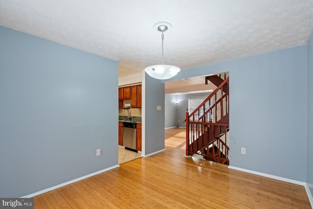 interior space with light hardwood / wood-style flooring, a textured ceiling, and sink