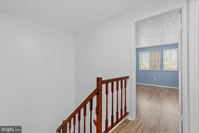 hallway featuring light wood-type flooring and a textured ceiling