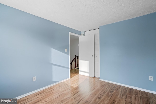 spare room featuring hardwood / wood-style floors and a textured ceiling