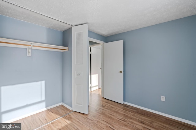 unfurnished bedroom with a textured ceiling and hardwood / wood-style flooring