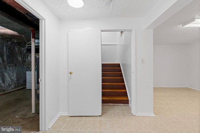 stairs with washer / dryer and a textured ceiling