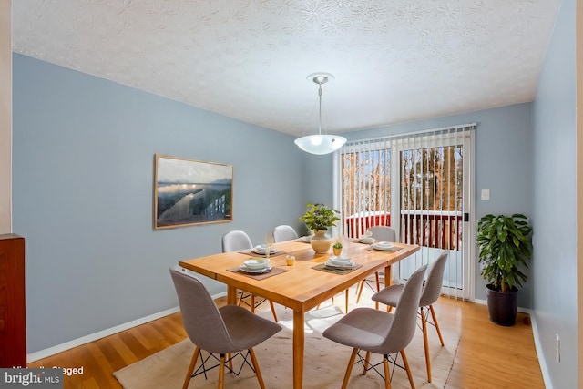 dining area featuring light hardwood / wood-style flooring and a textured ceiling