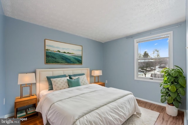 bedroom featuring a textured ceiling and hardwood / wood-style flooring