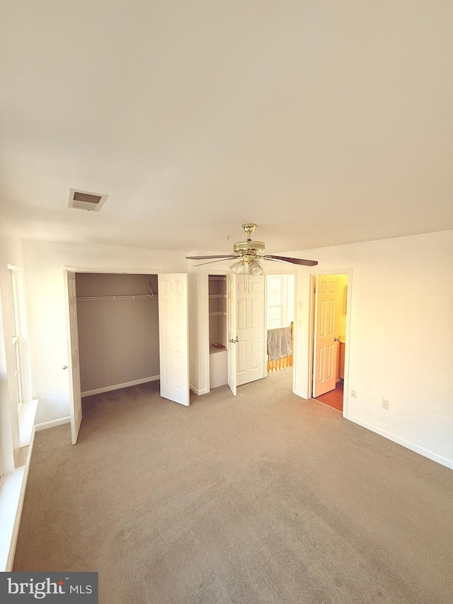 unfurnished bedroom with ceiling fan, a closet, and carpet floors