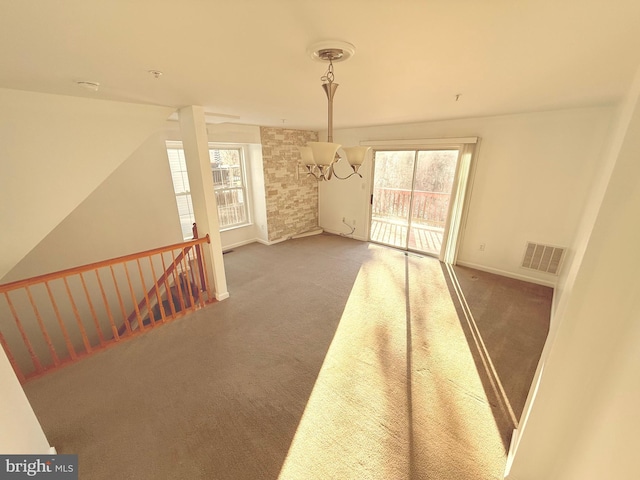 carpeted empty room with a chandelier