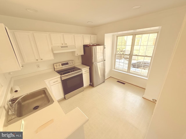 kitchen with stainless steel appliances, white cabinets, and sink