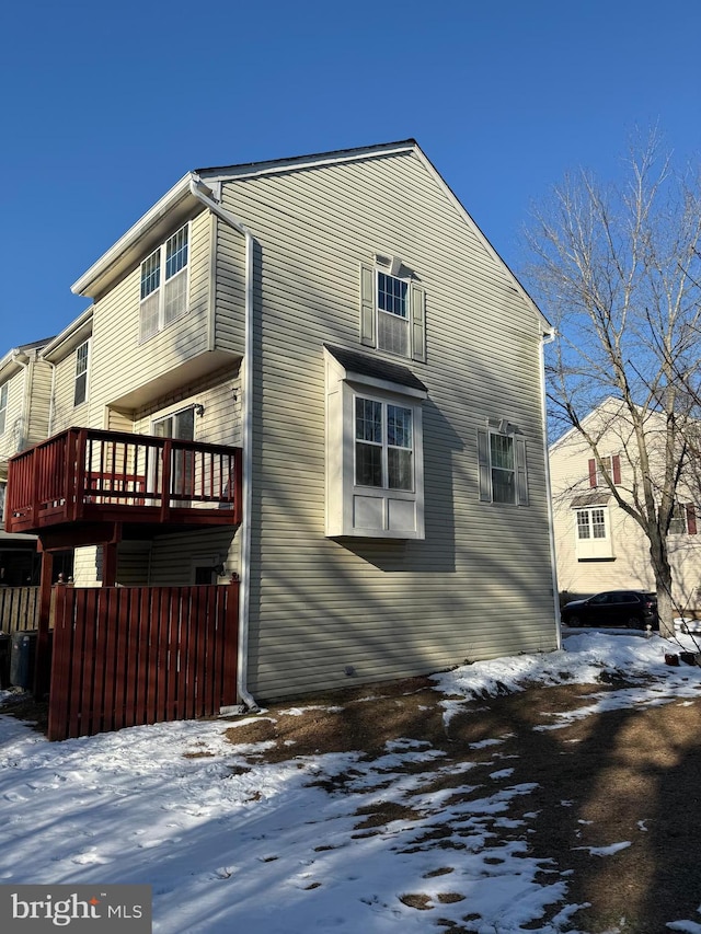 snow covered property with a deck