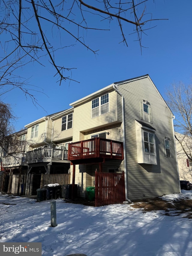 snow covered property with a deck