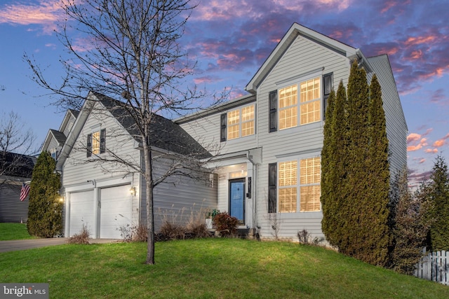 view of front property with a garage and a lawn