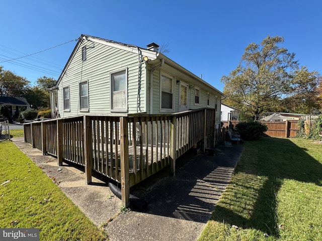 view of home's exterior featuring a lawn and a deck