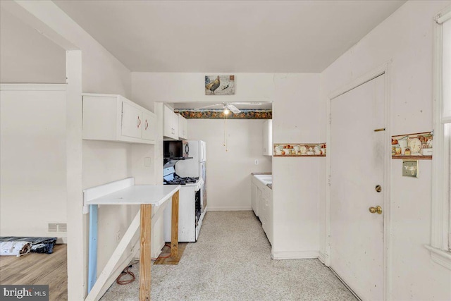 kitchen featuring white cabinets and white range with gas cooktop