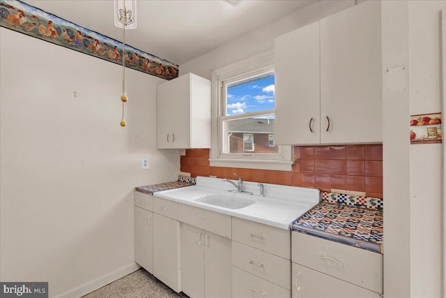 kitchen with sink, white cabinetry, and decorative backsplash