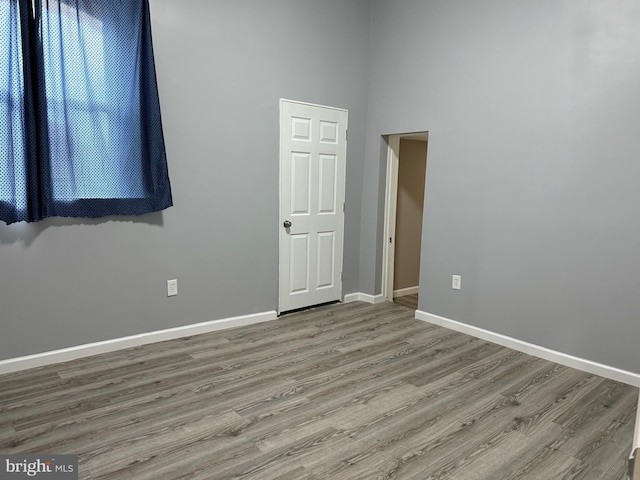 unfurnished room featuring hardwood / wood-style floors and a high ceiling