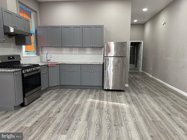 kitchen featuring gray cabinets, light stone countertops, sink, and appliances with stainless steel finishes