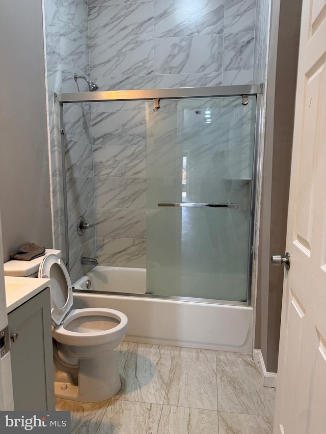 full bathroom with vanity, bath / shower combo with glass door, and toilet