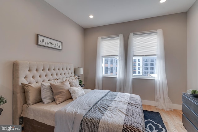 bedroom with multiple windows and light hardwood / wood-style floors