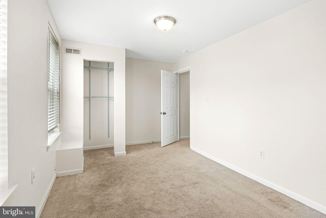 unfurnished bedroom with light carpet, baseboards, and visible vents