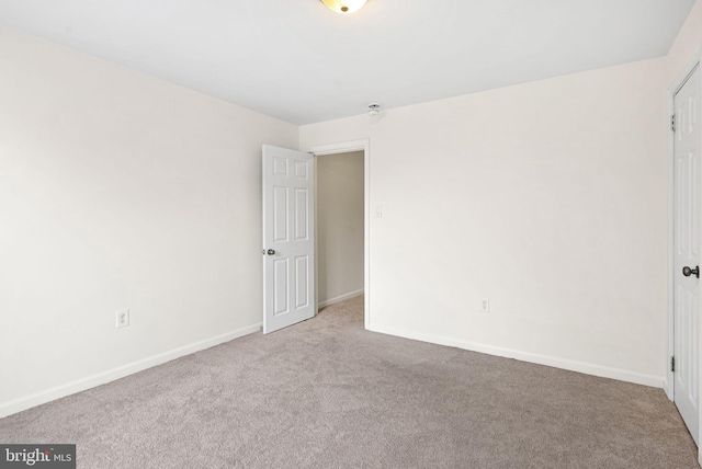 unfurnished bedroom with baseboards and light colored carpet