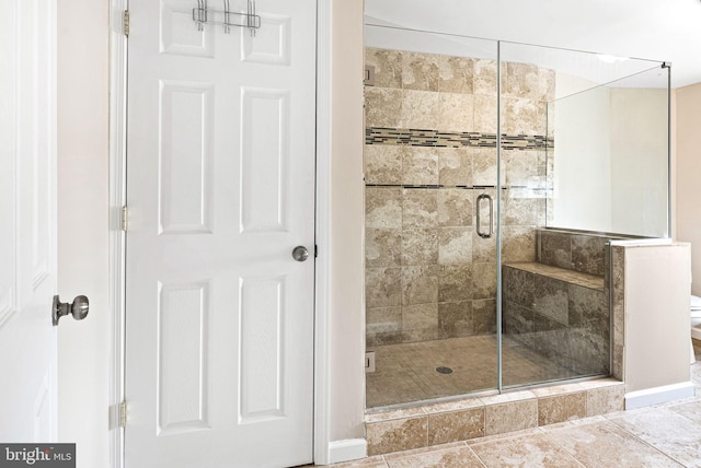 full bathroom featuring a shower stall and toilet