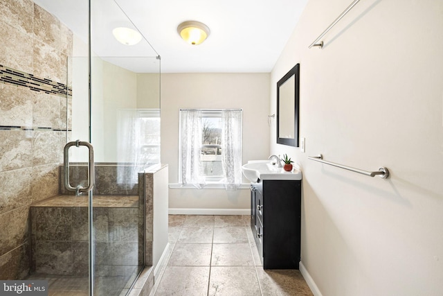 full bath with tiled shower, tile patterned flooring, vanity, and baseboards