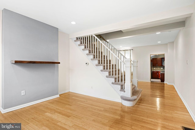 stairs with visible vents, baseboards, wood finished floors, and recessed lighting