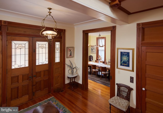 foyer entrance with crown molding and hardwood / wood-style floors