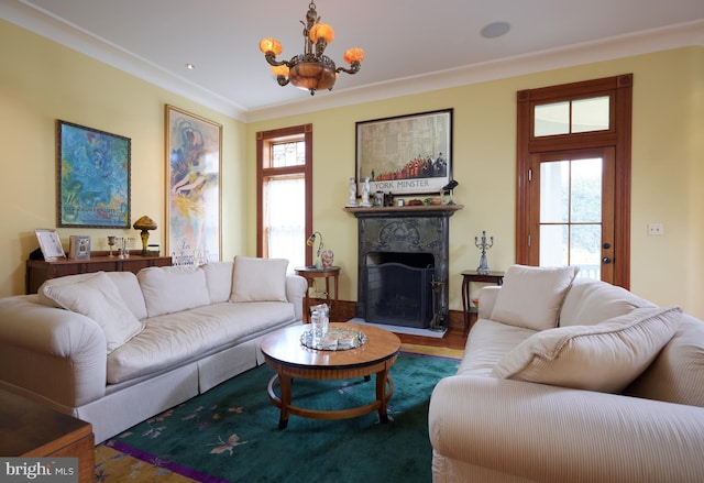 living room featuring ornamental molding, a healthy amount of sunlight, hardwood / wood-style flooring, and a notable chandelier