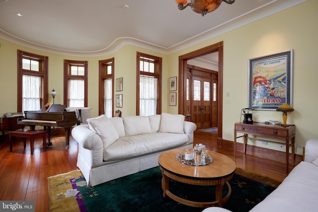 living room featuring hardwood / wood-style flooring, a wealth of natural light, and crown molding