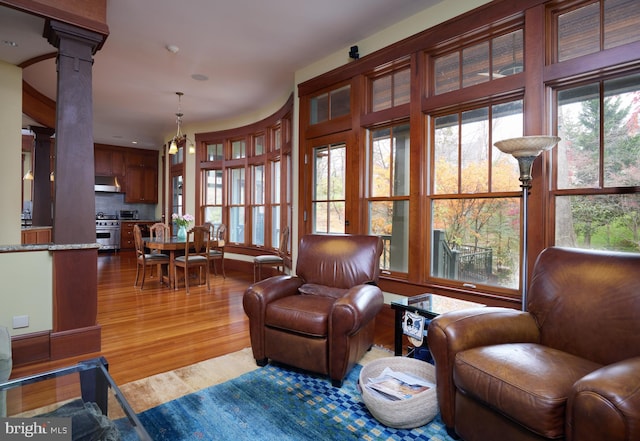 living area featuring wood-type flooring and ornate columns