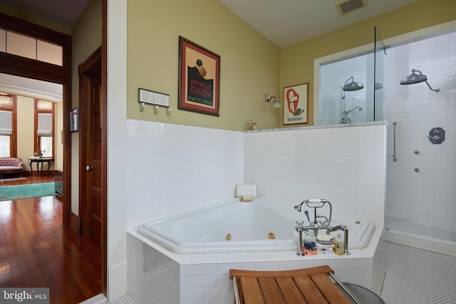 bathroom featuring hardwood / wood-style flooring and plus walk in shower