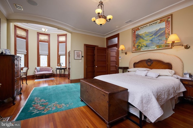 bedroom with a chandelier, wood-type flooring, and ornamental molding