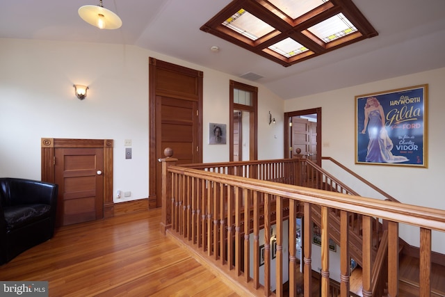 hall featuring lofted ceiling and hardwood / wood-style flooring