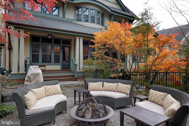 view of patio with an outdoor living space with a fire pit