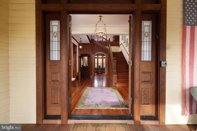 interior space with hardwood / wood-style flooring and wood walls