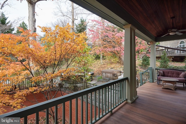 wooden terrace featuring ceiling fan and a hot tub