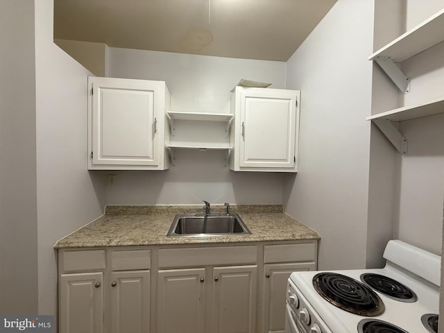 kitchen with white cabinets, white electric range, and sink