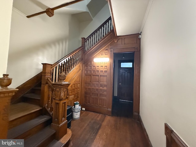 stairs with wood-type flooring and ornamental molding