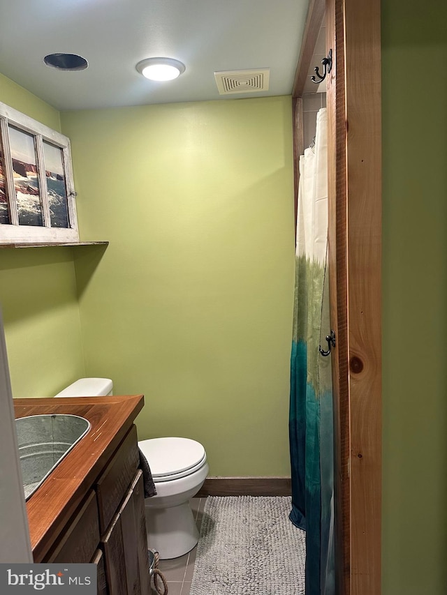 bathroom featuring toilet, vanity, and tile patterned floors